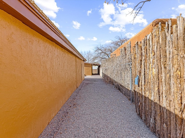 view of home's exterior with fence and stucco siding