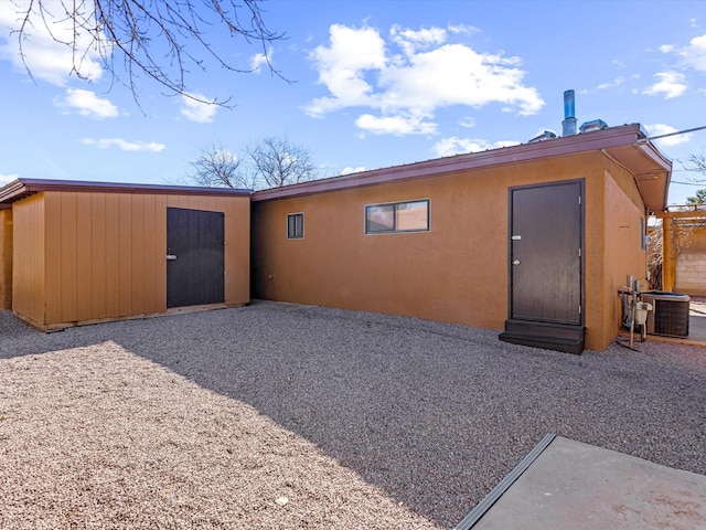 rear view of house with cooling unit and an outdoor structure