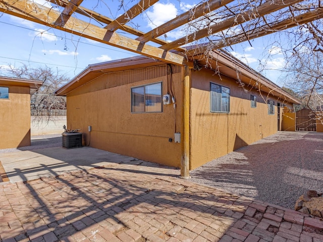 view of property exterior featuring a gate, fence, and a patio