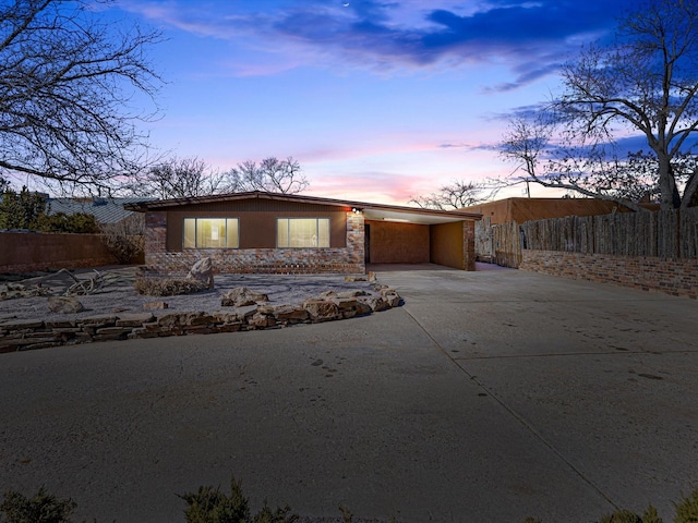 mid-century home with driveway, fence, and a carport