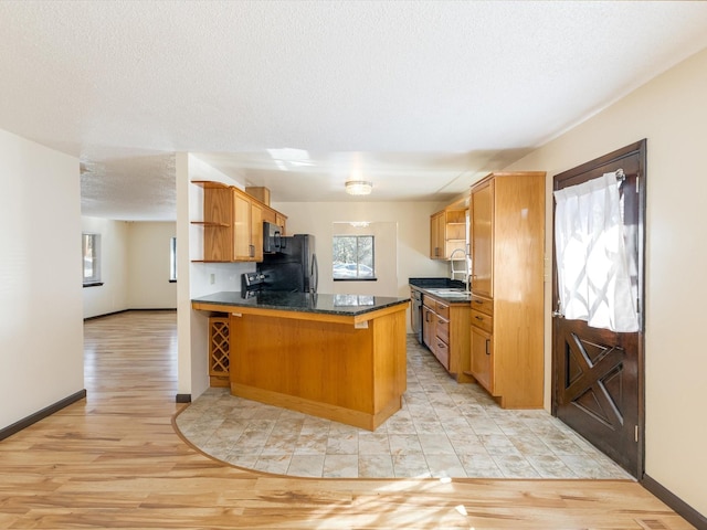 kitchen with a peninsula, light wood-type flooring, and plenty of natural light