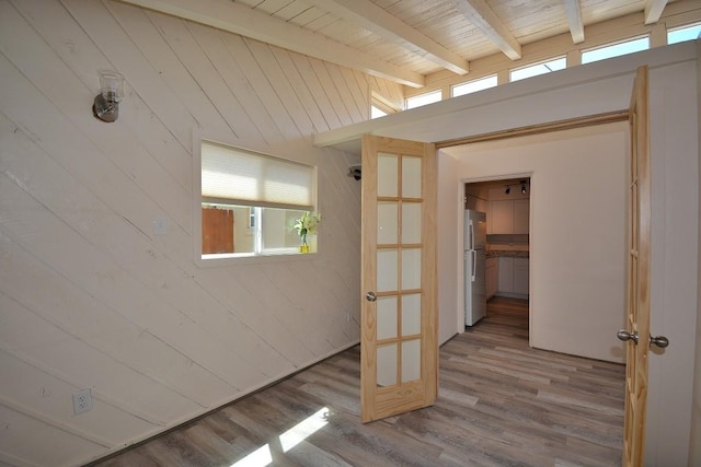 interior space featuring a healthy amount of sunlight, wooden walls, hardwood / wood-style floors, and wooden ceiling