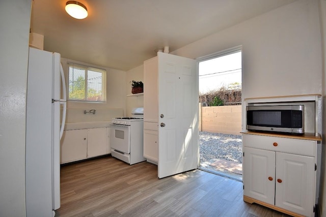 kitchen with white cabinetry, white appliances, and light wood-type flooring