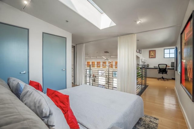 bedroom with light wood-type flooring and a skylight