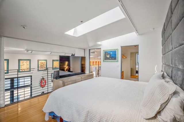 bedroom featuring light hardwood / wood-style flooring and a skylight