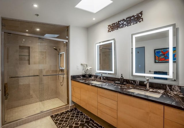 bathroom featuring vanity, tile patterned flooring, a skylight, and walk in shower