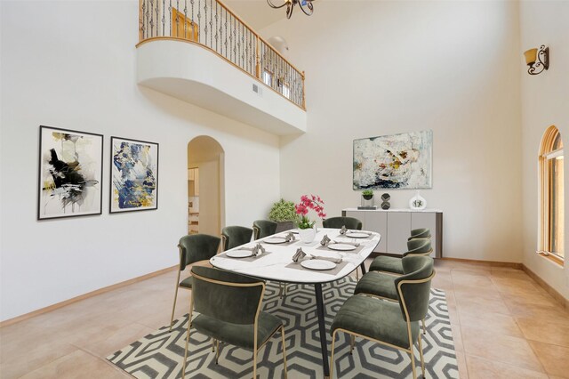 dining room featuring light tile patterned floors and a towering ceiling