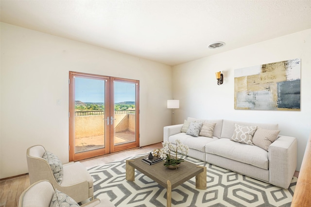 living room with french doors and light wood-type flooring