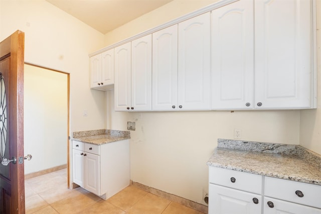 washroom with washer hookup, cabinets, and light tile patterned flooring