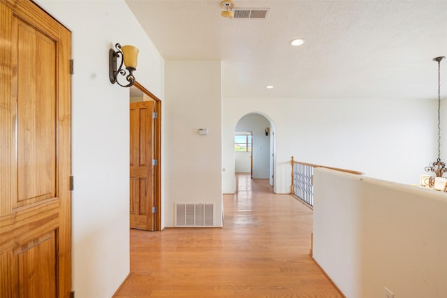 corridor with light hardwood / wood-style floors