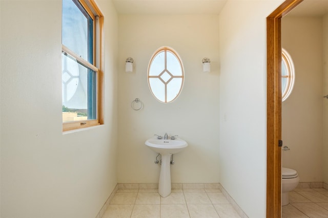 bathroom featuring tile patterned floors, toilet, and a wealth of natural light