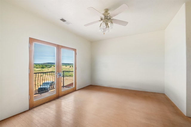 spare room with french doors, ceiling fan, and light wood-type flooring