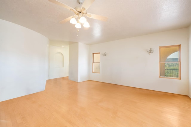 empty room featuring ceiling fan, a textured ceiling, and light wood-type flooring