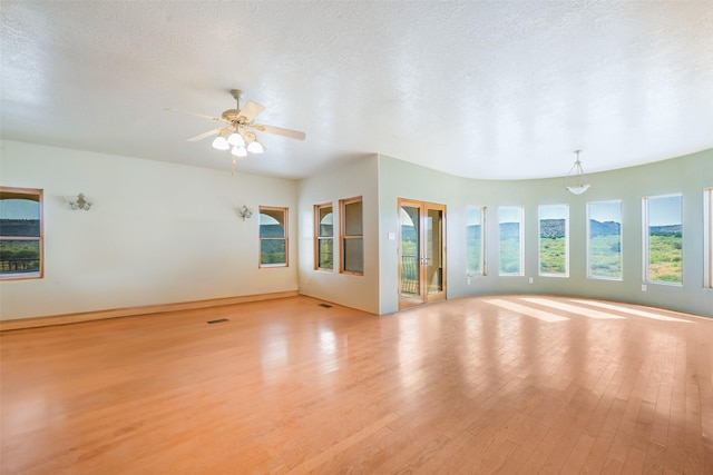 interior space featuring ceiling fan, a textured ceiling, and light wood-type flooring