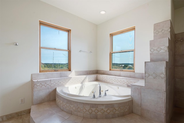 bathroom with tiled tub and tile patterned flooring