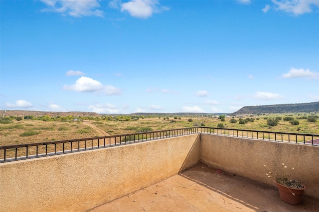 view of patio / terrace featuring a rural view and a balcony