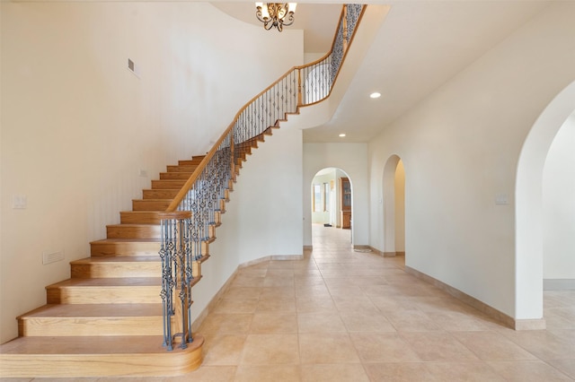 stairway featuring a towering ceiling and tile patterned flooring