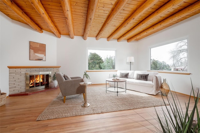 living room with wood ceiling, a fireplace, light hardwood / wood-style floors, and beam ceiling