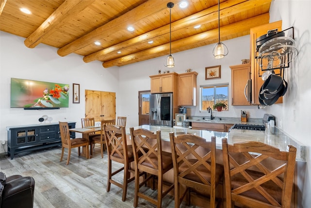 kitchen featuring sink, wood ceiling, beam ceiling, stainless steel appliances, and kitchen peninsula