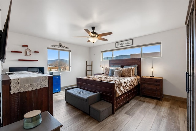 bedroom featuring hardwood / wood-style flooring, a mountain view, and ceiling fan