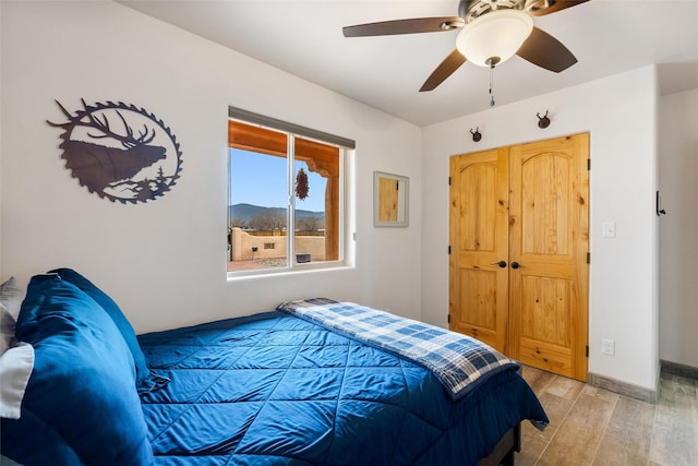 bedroom featuring light hardwood / wood-style floors, a closet, and ceiling fan