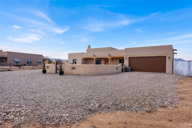 pueblo-style home featuring a garage