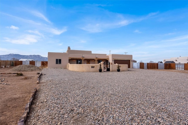 rear view of property featuring a garage and a mountain view