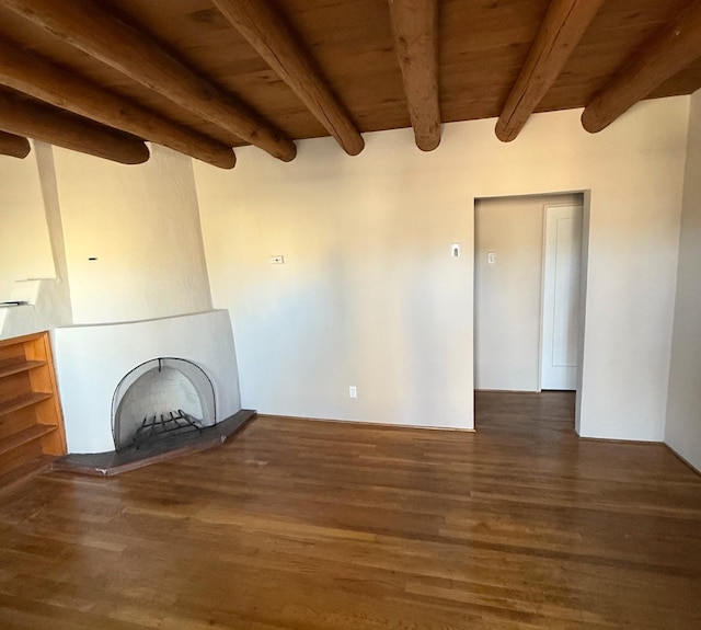 unfurnished living room with beam ceiling, dark wood-type flooring, a fireplace, and wood ceiling