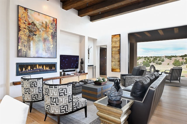 living room featuring beam ceiling and light hardwood / wood-style floors