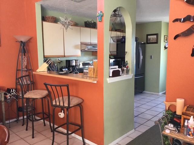 kitchen featuring white cabinetry, stainless steel range, black fridge, and light tile patterned floors