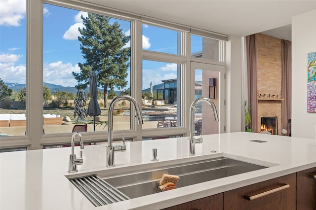 interior details featuring a stone fireplace, a mountain view, and sink