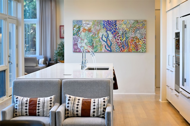 dining space with sink and light hardwood / wood-style flooring