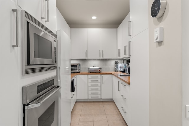 kitchen featuring white cabinetry, light tile patterned floors, tasteful backsplash, and appliances with stainless steel finishes