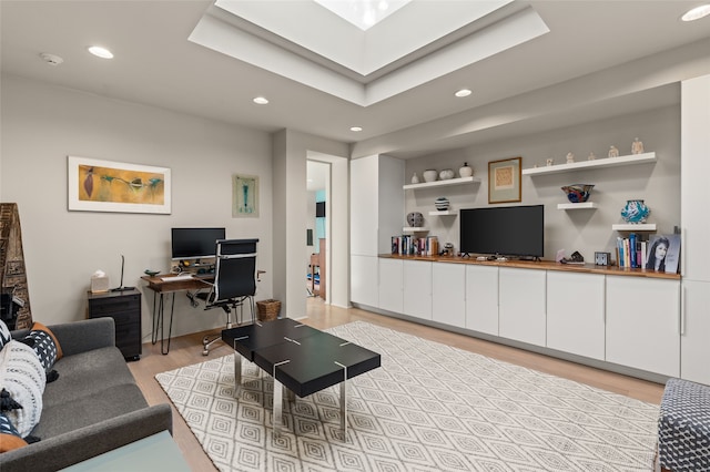 living room featuring light hardwood / wood-style floors and a skylight