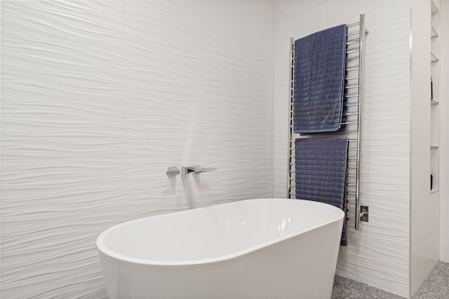 bathroom featuring tile walls and a tub