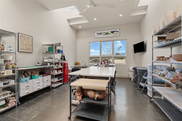 kitchen featuring white cabinetry, ceiling fan, a center island, and dark tile patterned flooring