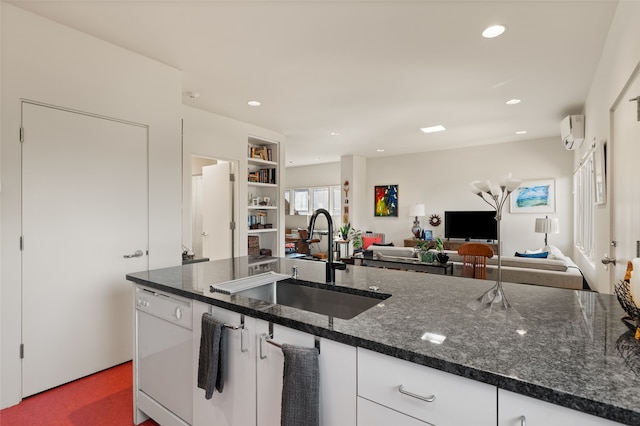 kitchen with sink, dishwasher, white cabinetry, a wall unit AC, and dark stone counters