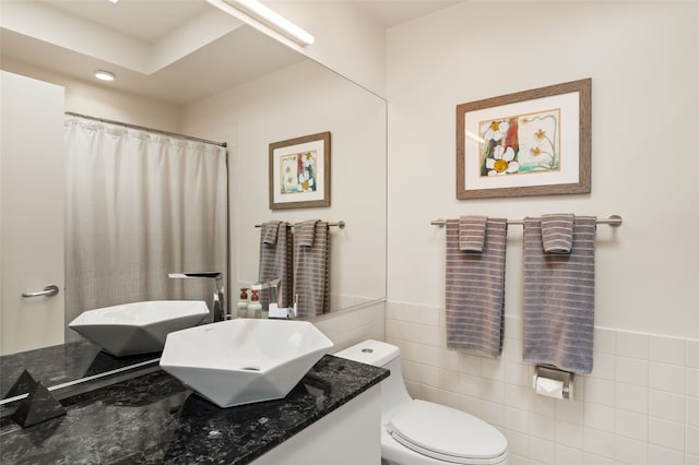 bathroom featuring vanity, tile walls, a shower with shower curtain, and toilet