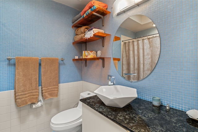 bathroom featuring vanity, tile walls, curtained shower, and toilet