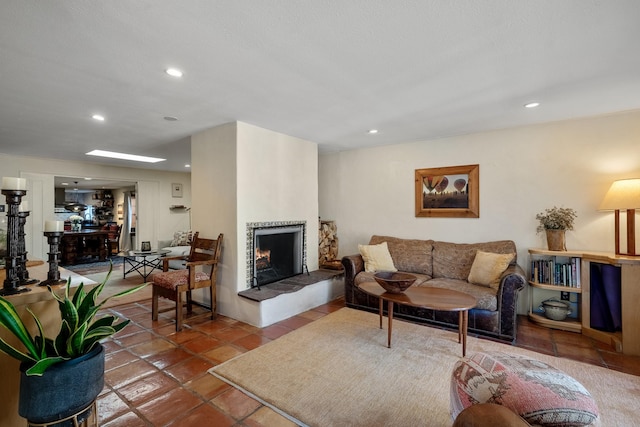 living area featuring recessed lighting, a warm lit fireplace, and tile patterned flooring