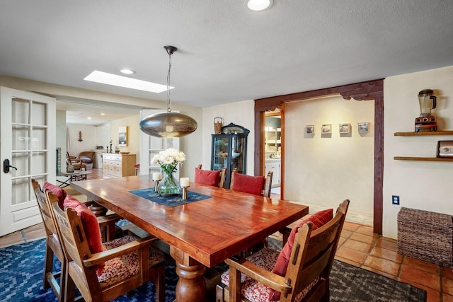 dining area with a skylight, a textured ceiling, and recessed lighting