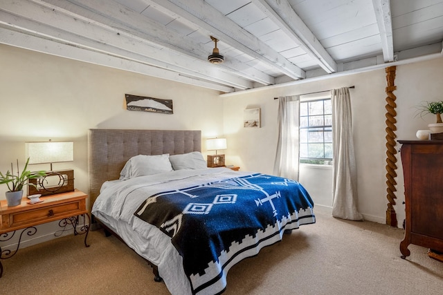 carpeted bedroom featuring beam ceiling and baseboards