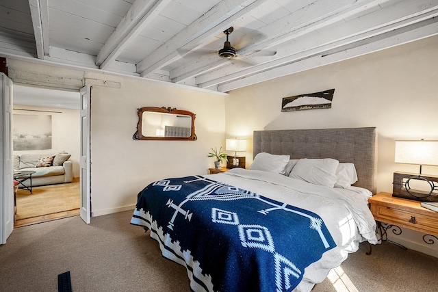 carpeted bedroom with ceiling fan, baseboards, and beamed ceiling