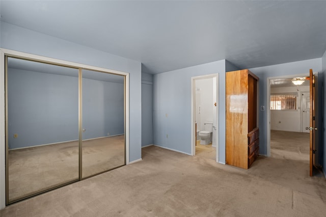 unfurnished bedroom with ensuite bathroom and light colored carpet