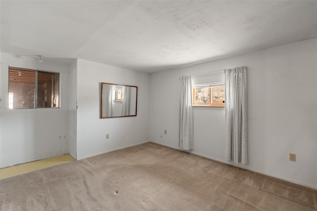 carpeted spare room with a textured ceiling