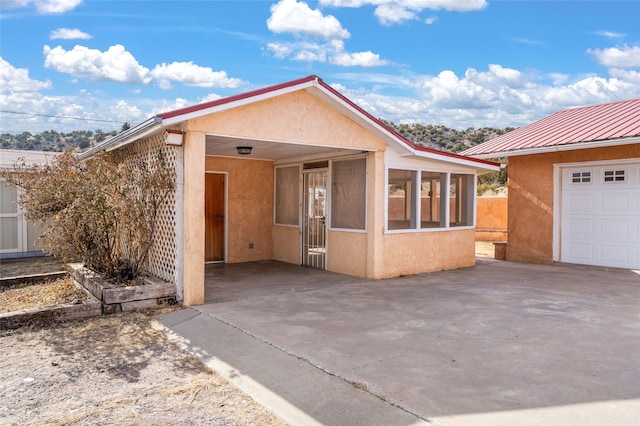 view of front of property featuring a garage and a sunroom