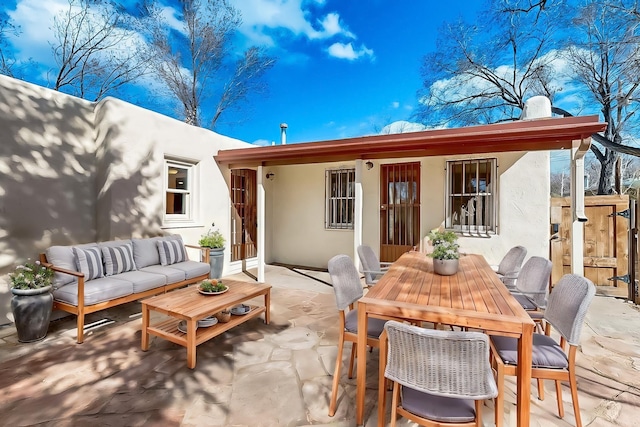 rear view of house with an outdoor living space and a patio