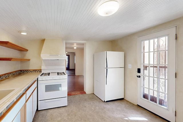 kitchen featuring custom exhaust hood, white cabinetry, light carpet, and white appliances