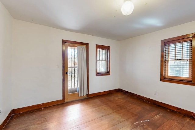 unfurnished room featuring dark wood-type flooring and plenty of natural light