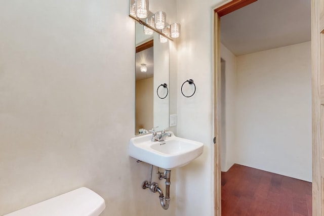 bathroom with hardwood / wood-style flooring and toilet